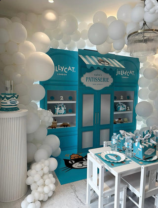 Jellycat Patisserie Birthday Backdrop | Blue shop-style display with personalised signage, shelves and themed party details