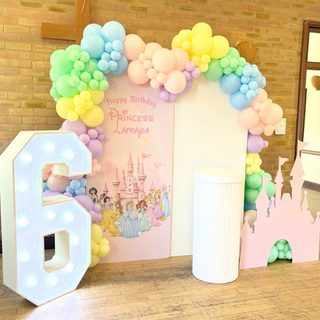 Disney Princess Birthday Backdrop | Pastel balloon arch with princess castle backdrop, cake plinth and number prop