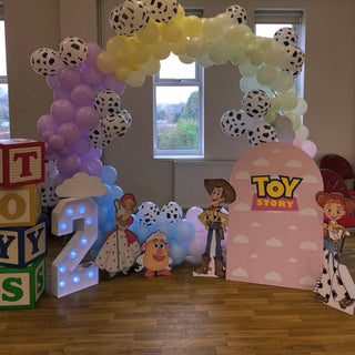 Toy Story Birthday Backdrop | Pastel balloon arch with Woody, Jessie, Bo Peep and themed character cut-outs